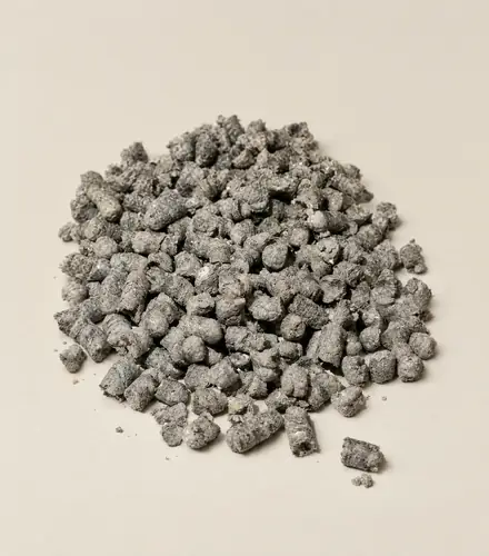 A loose heap of grey HLB-FIBER pellets, short rough cylinders, on off-white paper
